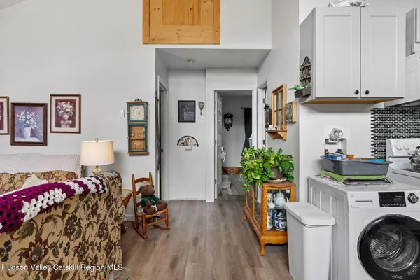 a view of a kitchen with furniture and wooden floor