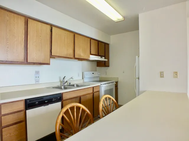 a kitchen with stainless steel appliances granite countertop a sink a stove and cabinets