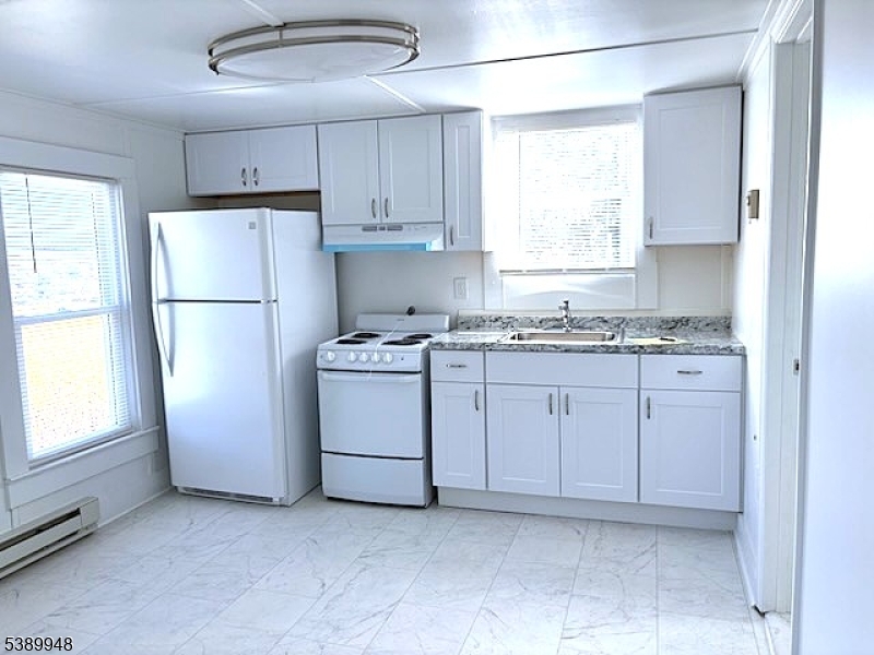 a kitchen with cabinets appliances a sink and a window