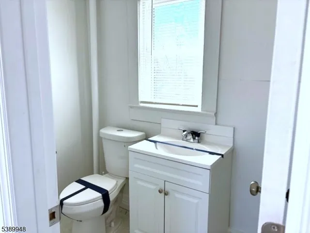 a bathroom with a sink a toilet and a window
