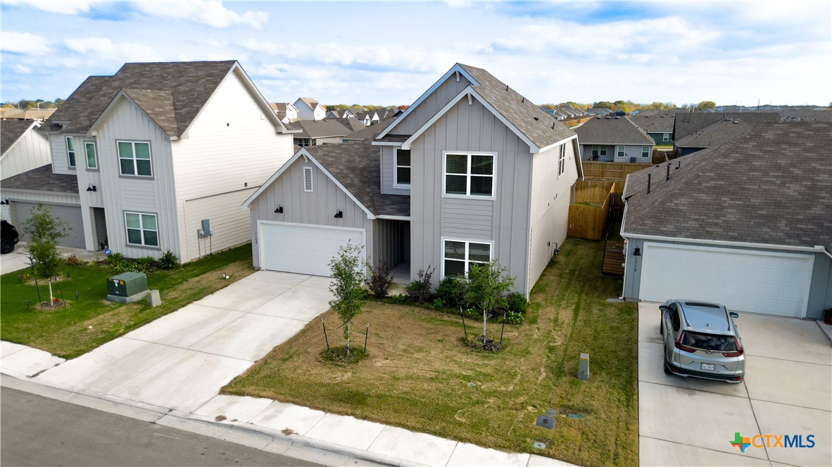 1708 Violeteared Way Lockhart, TX 78644 - Photo 2 of 25 a view of a white house next to a yard with potted plants