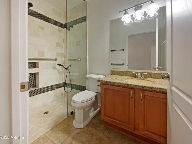 a bathroom with a sink a toilet a mirror and shower