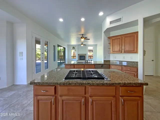a kitchen with granite countertop a sink a stove and cabinets