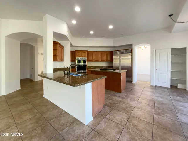 a kitchen with stainless steel appliances granite countertop a sink and a refrigerator