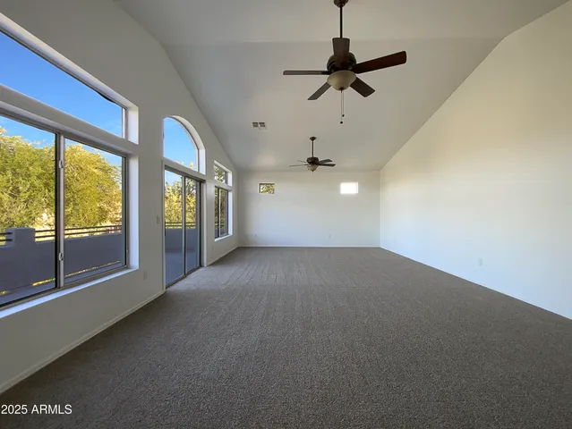 a view of a livingroom with a ceiling fan and window