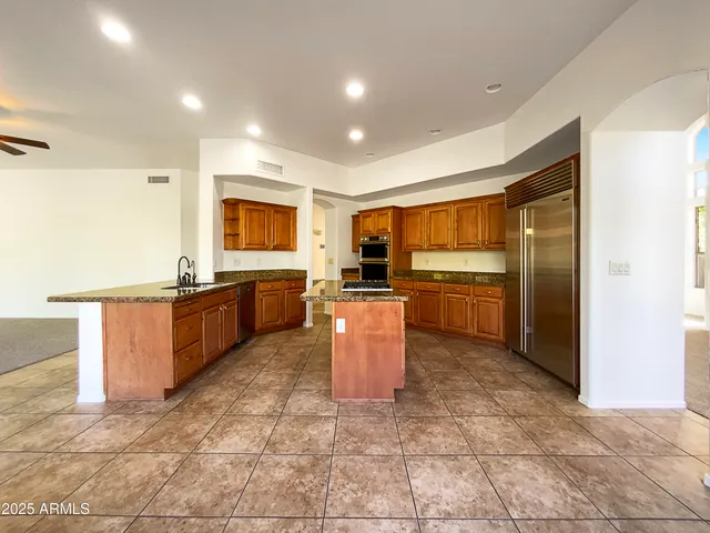 a kitchen with stainless steel appliances granite countertop a stove a sink and a refrigerator