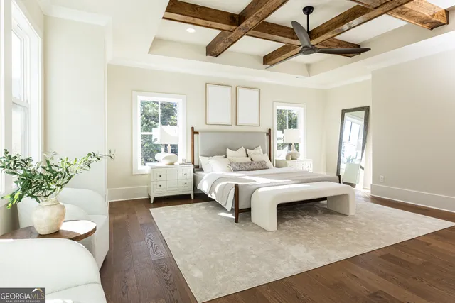 a bedroom with a large bed chandelier and a window