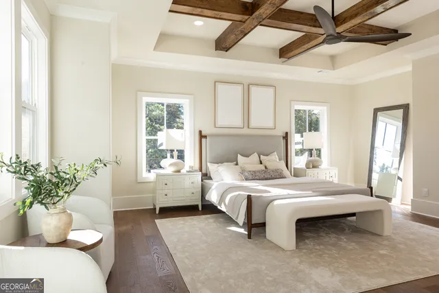 a bedroom with a large bed and windows