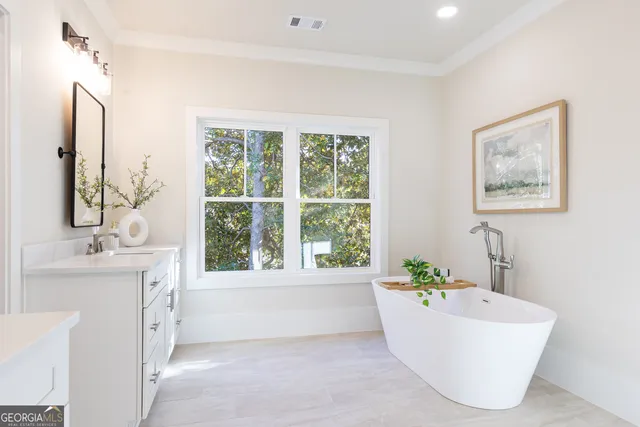 a bathroom with a tub a sink and a large mirror