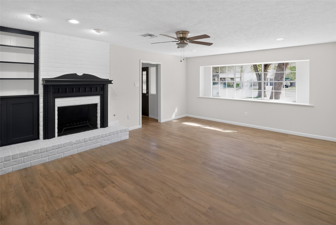 133 Cherry Tree Lane Friendswood, TX 77546 - Photo 2 of 27 a view of an empty room with a fireplace and a window