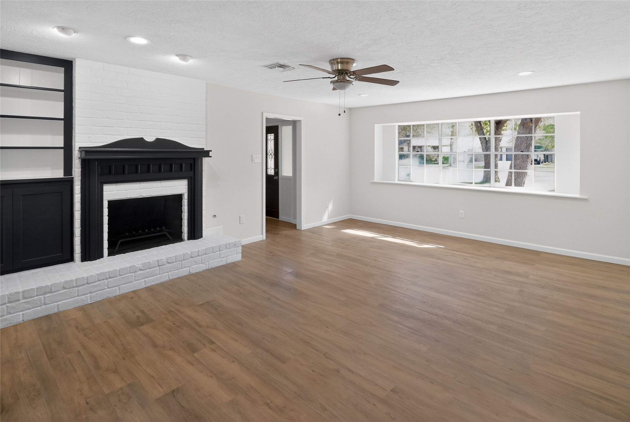133 Cherry Tree Lane Friendswood, TX 77546 - Photo 2 of 27 a view of an empty room with a window and fireplace