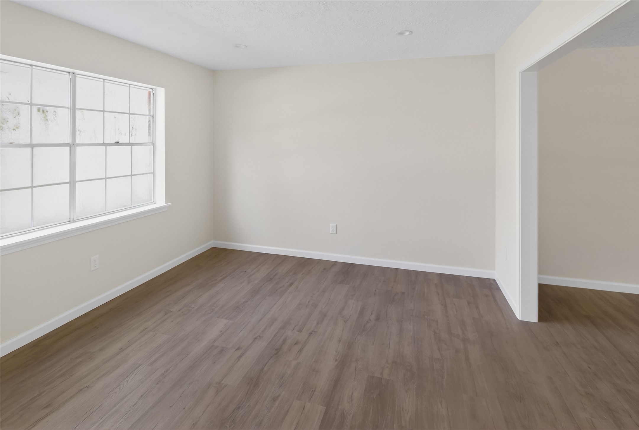 133 Cherry Tree Lane Friendswood, TX 77546 - Photo 5 of 27 an empty room with wooden floor and windows