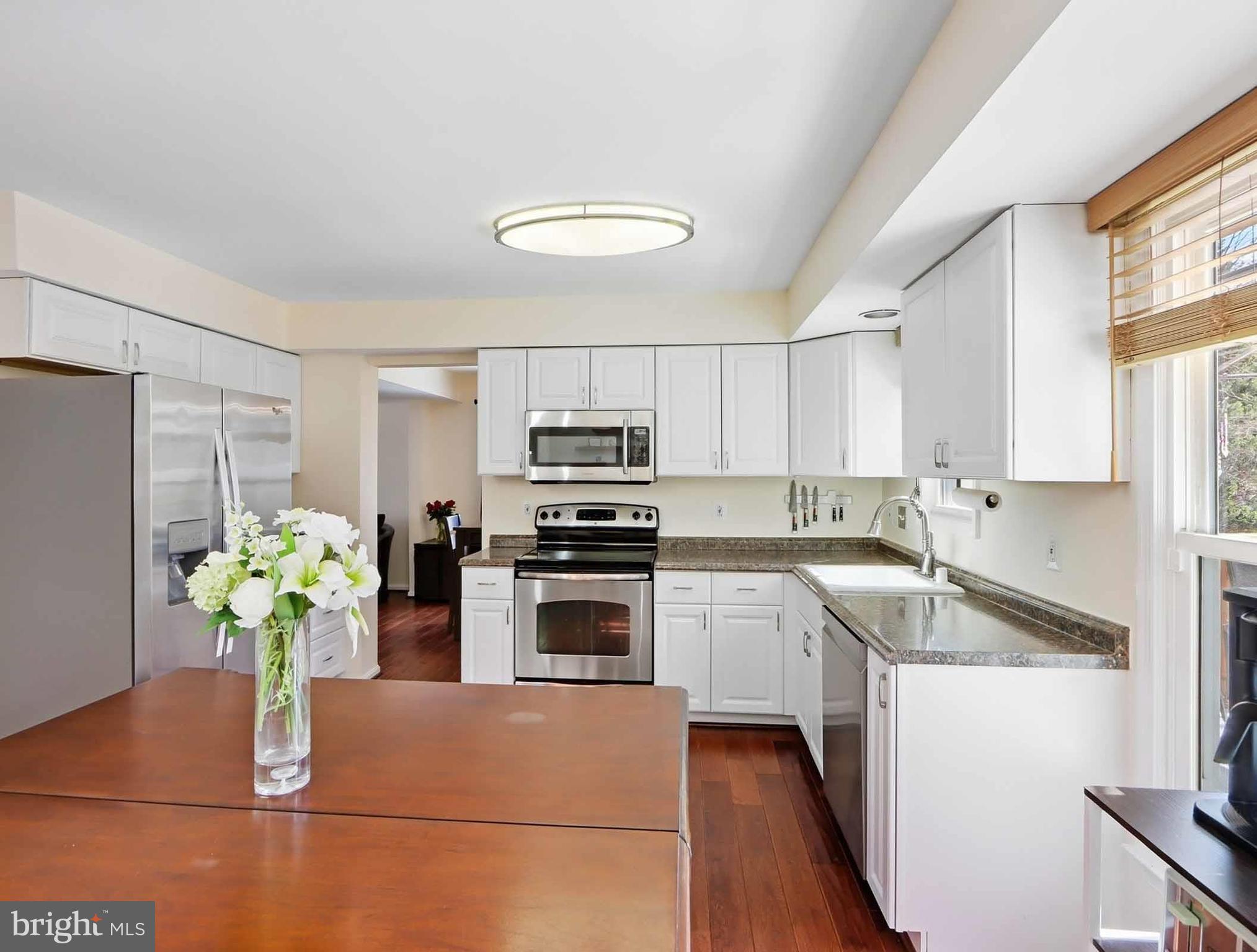 12208 Stoney Bottom Road Germantown, MD 20874 - Photo 11 of 52 a kitchen with stainless steel appliances granite countertop a sink a stove a refrigerator a faucet a cabinetry and a potted plant
