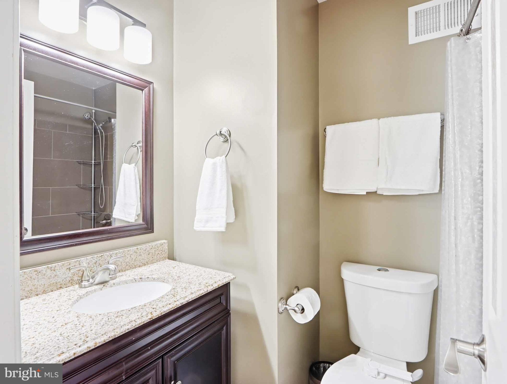 12208 Stoney Bottom Road Germantown, MD 20874 - Photo 33 of 52 a bathroom with a granite countertop toilet sink and mirror