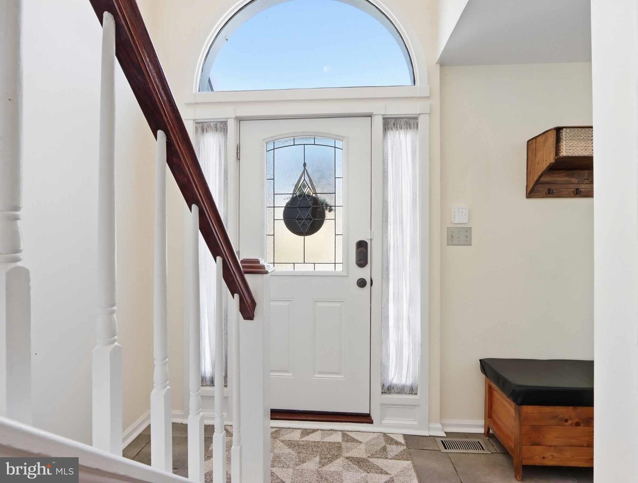 12208 Stoney Bottom Road Germantown, MD 20874 - Photo 7 of 52 a hallway with front door wooden floor and stairs