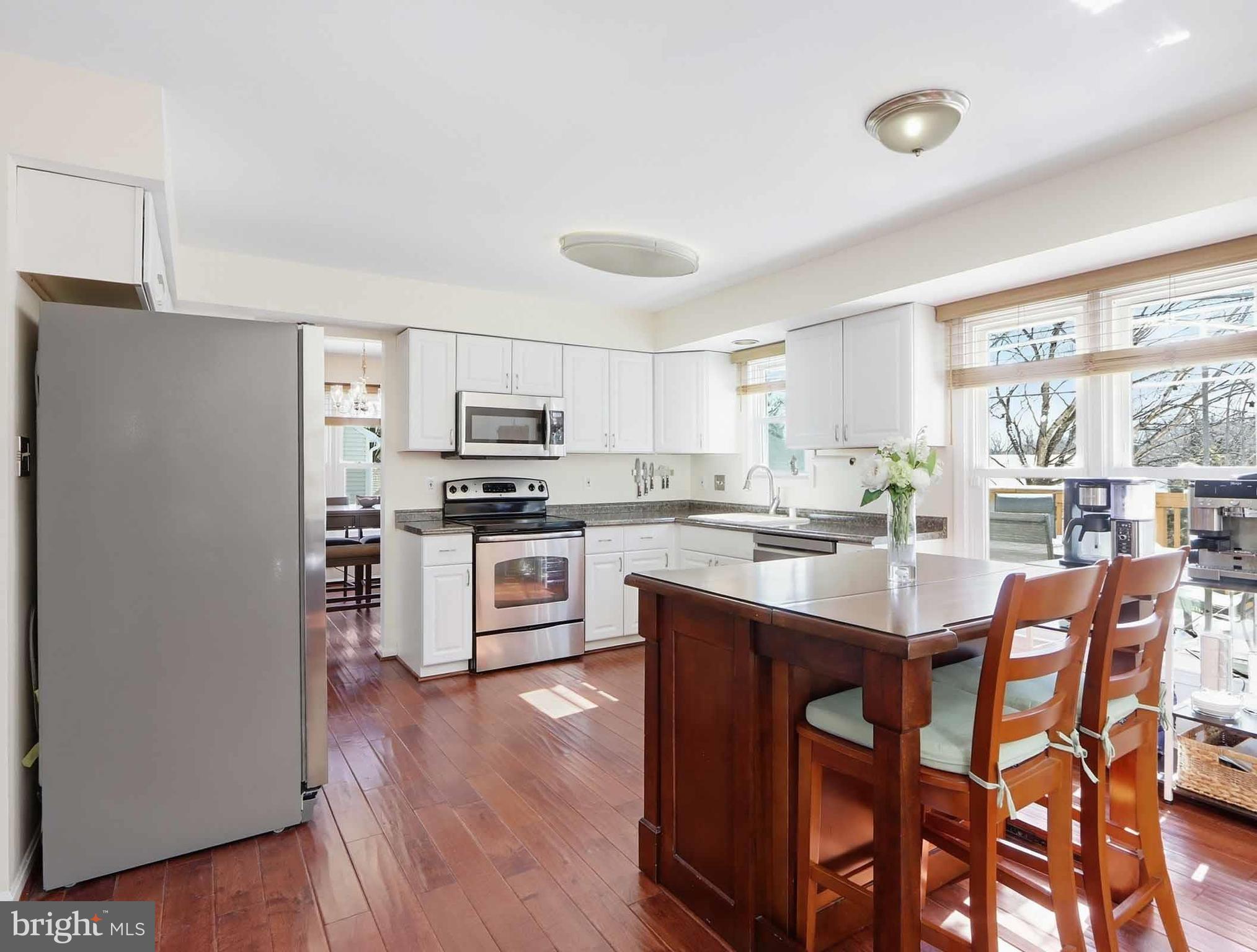 12208 Stoney Bottom Road Germantown, MD 20874 - Photo 10 of 52 a kitchen with stainless steel appliances granite countertop a refrigerator a stove top oven a sink dishwasher and white cabinets with wooden floor