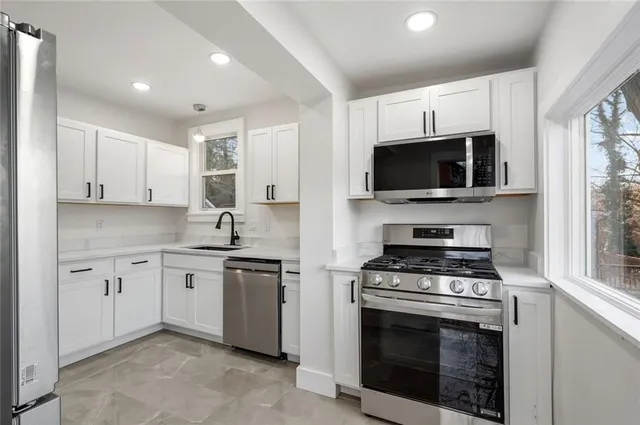 a kitchen with stainless steel appliances a stove microwave and sink