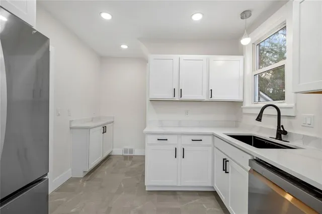 a view of a kitchen with white cabinets