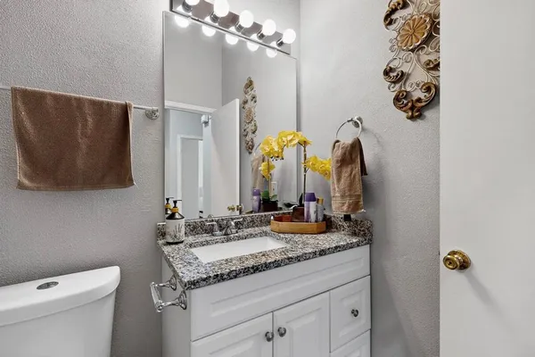 a bathroom with a granite countertop sink and a mirror