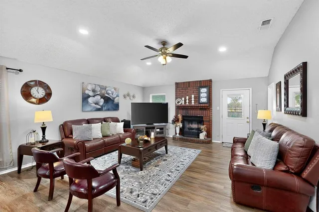 a living room with furniture a fireplace and a flat screen tv