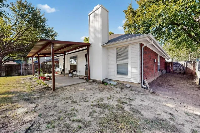 a view of a patio with table and chairs potted plants and large tree