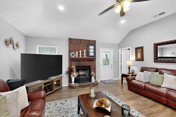a living room with furniture a flat screen tv and a fireplace
