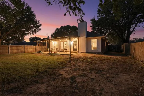 a view of house with backyard and trees