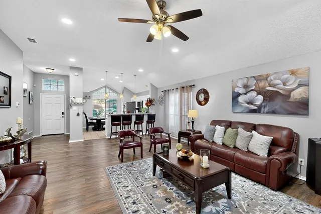 a living room with furniture kitchen view and a chandelier