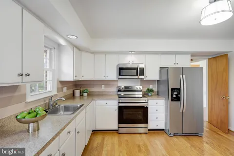 a kitchen with stainless steel appliances a stove cabinets sink and refrigerator