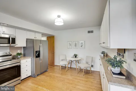 a living room with furniture a refrigerator and a dining table