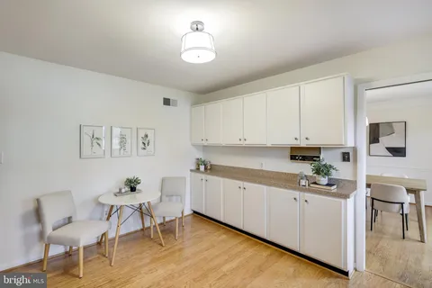 a kitchen with cabinets and chairs