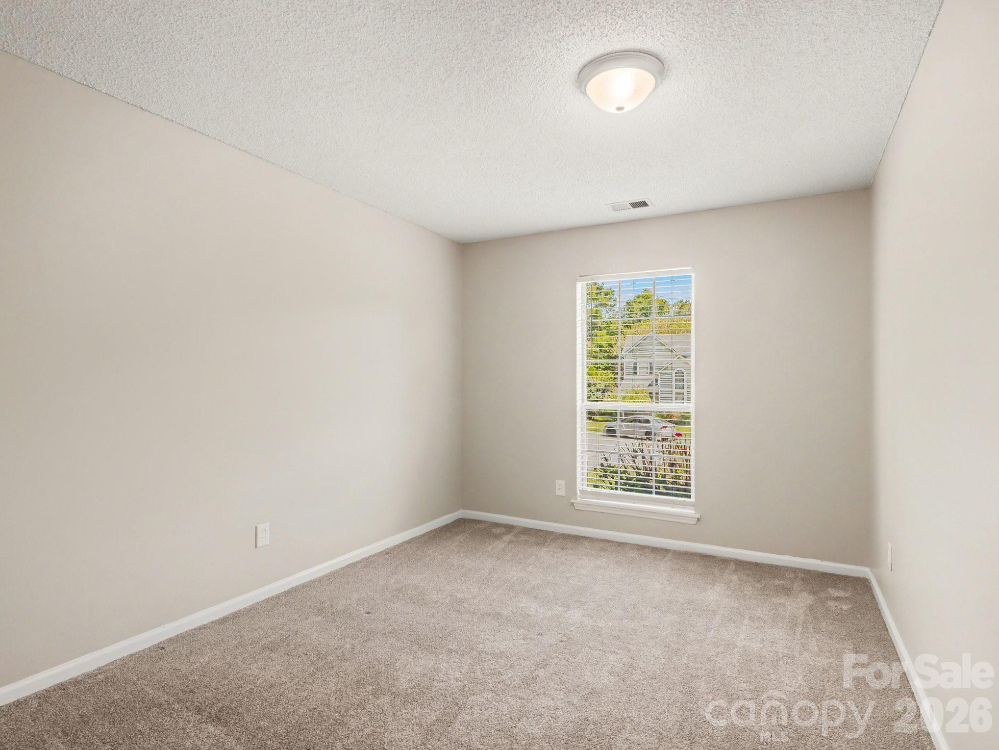 9214 Rotherham Lane Charlotte, NC 28216 - Photo 17 of 20 an empty room with windows