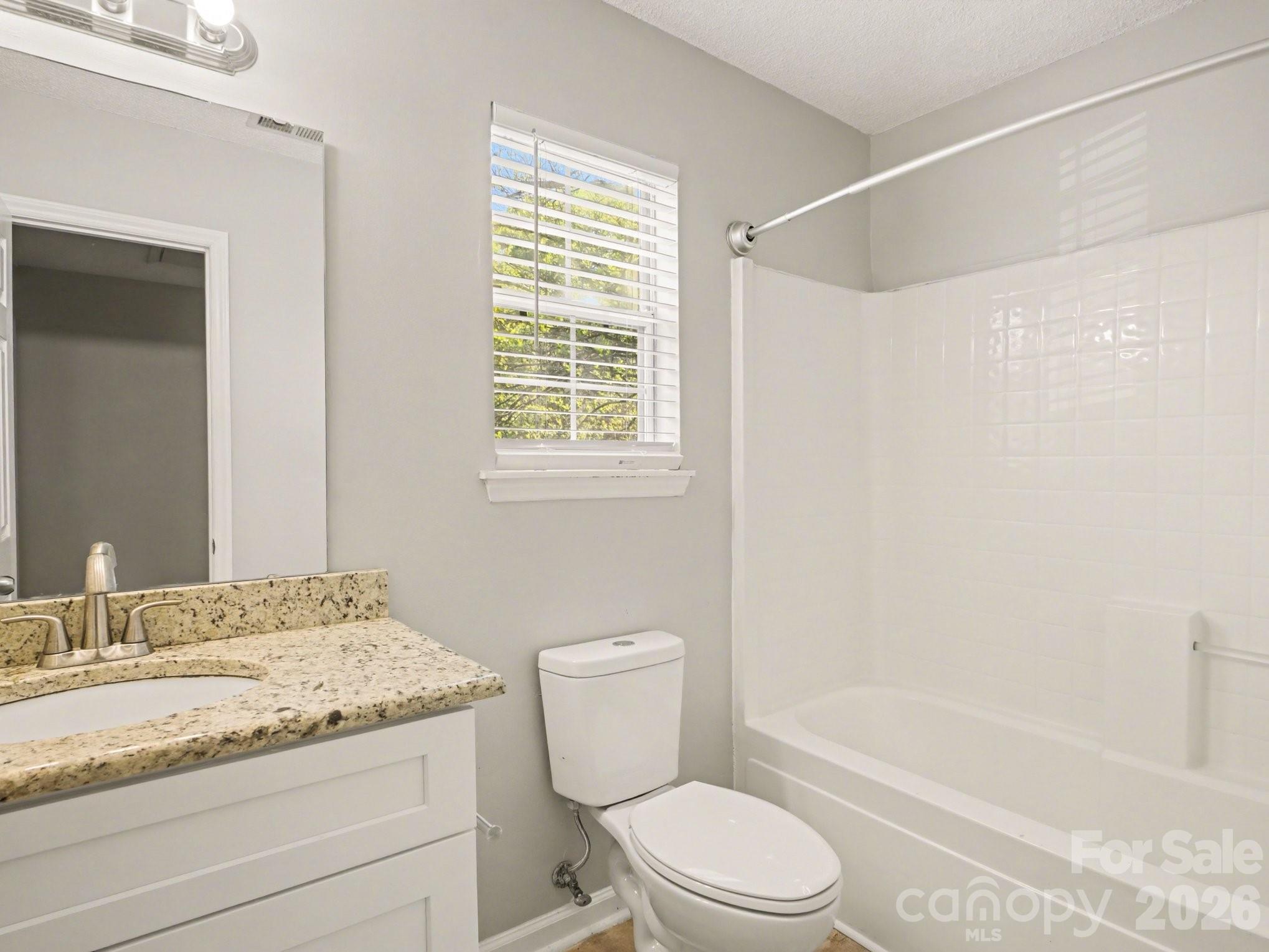 9214 Rotherham Lane Charlotte, NC 28216 - Photo 10 of 20 a bathroom with a granite countertop toilet a sink and bathtub