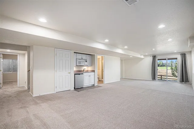 an empty room with closet and windows