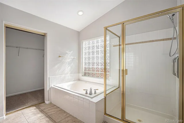 an empty room with wooden floor chandelier fan and windows