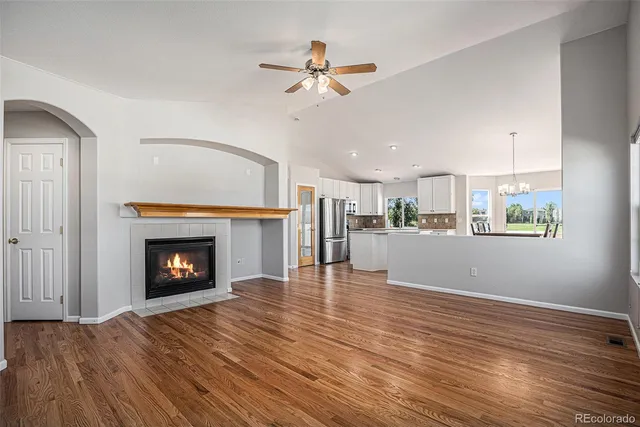 a view of empty room with wooden floor and fireplace