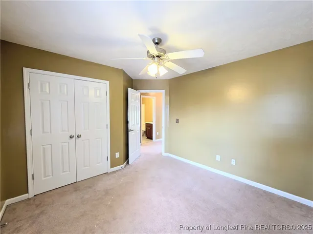 a view of an empty room with a ceiling fan and a window