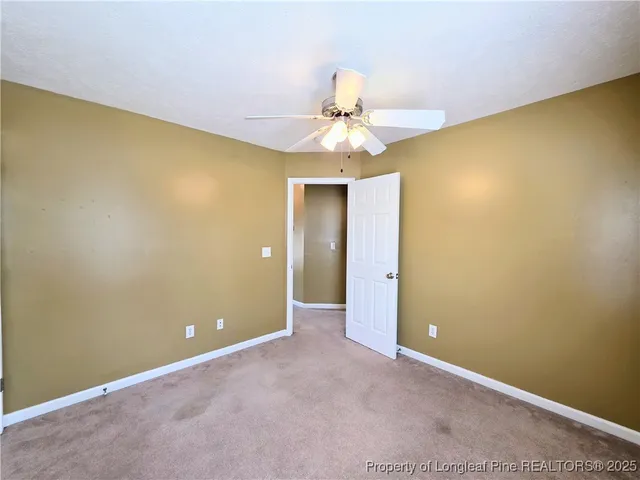 an empty room with a chandelier fan and a chandelier