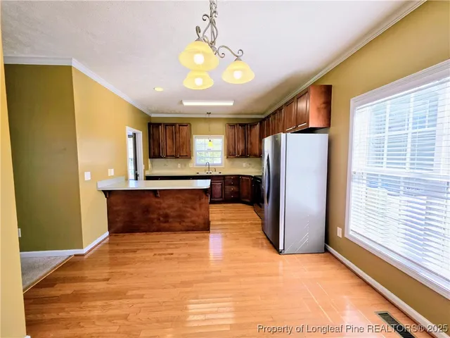 a view of kitchen with a refrigerator and a microwave
