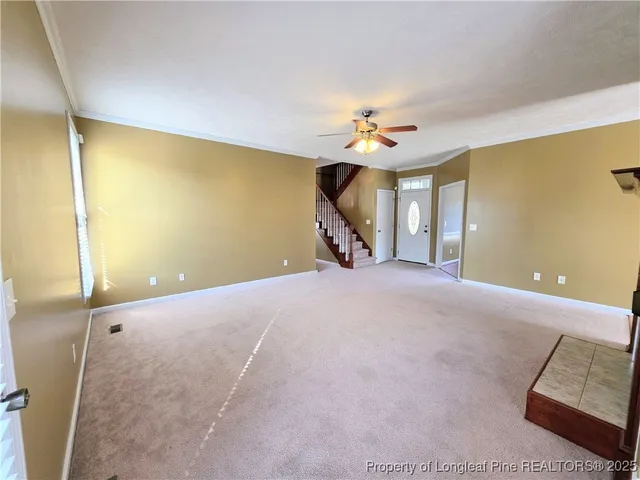 a furnished livingroom with a ceiling fan