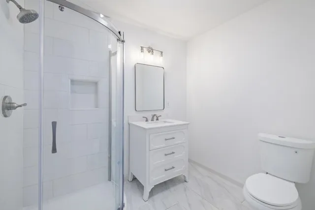 a bathroom with a granite countertop toilet sink and mirror