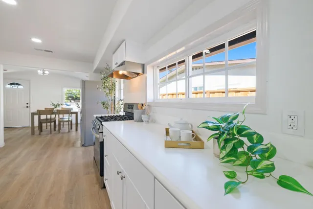 a kitchen with stainless steel appliances a sink a counter top space and a window