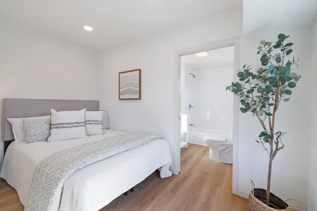 a bedroom with a large bed and a potted plant