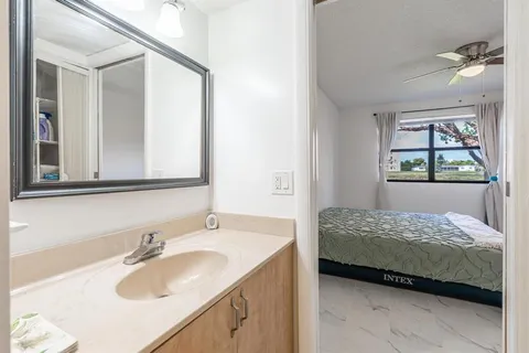 a bedroom with a sink and a mirror