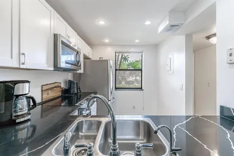 a view of a kitchen with a sink and a large window