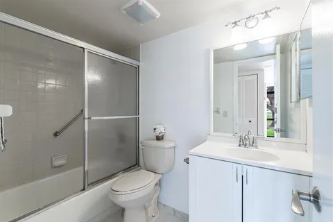 a bathroom with a granite countertop sink toilet and shower