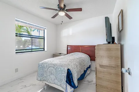 a bedroom with a bed and a flat tv screen on the dresser