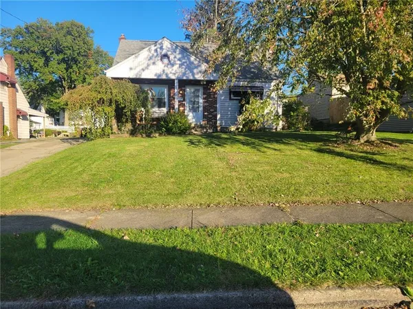 a front view of a house with yard and green space