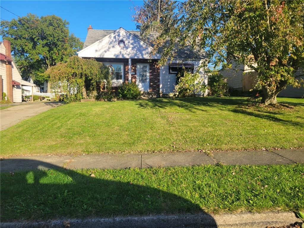 a front view of a house with yard and green space