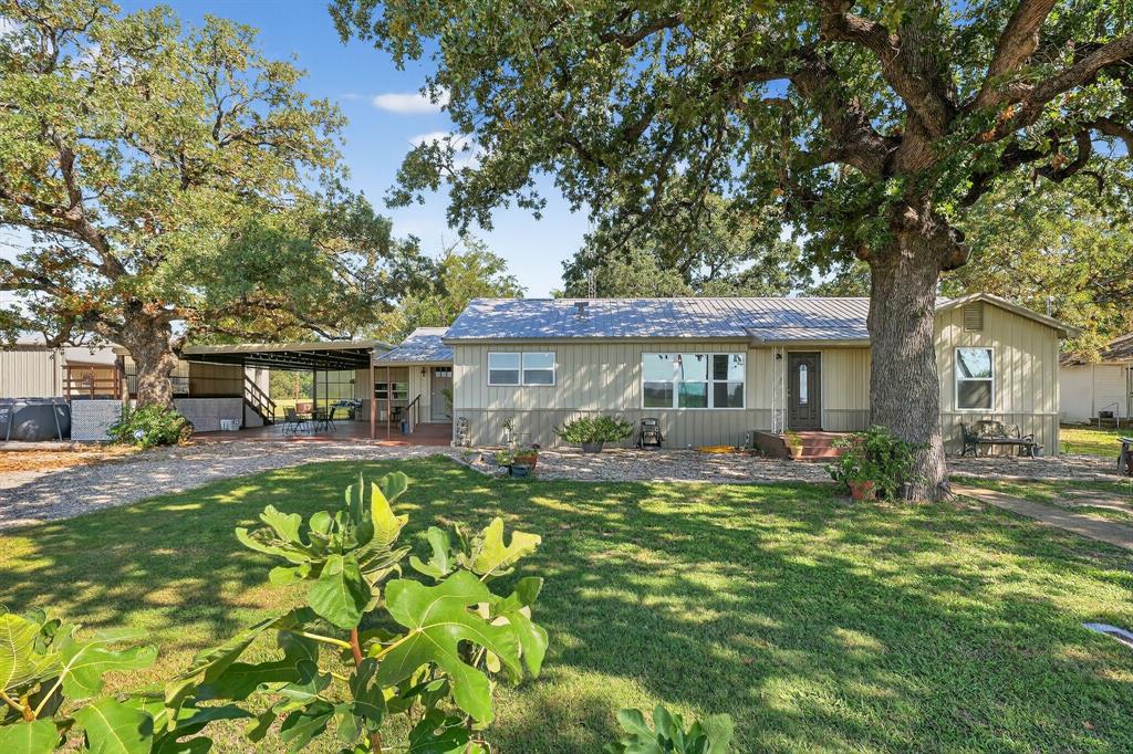 a front view of a house with a garden and trees